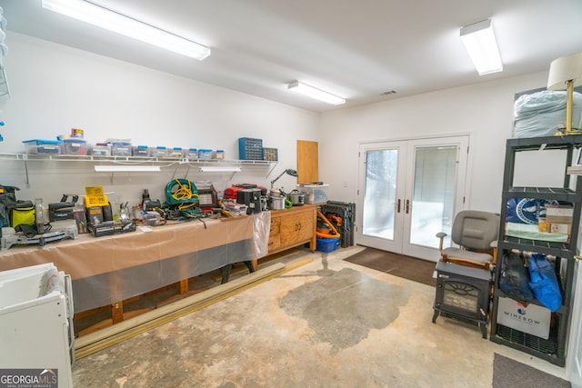 misc room featuring a workshop area, concrete floors, and french doors