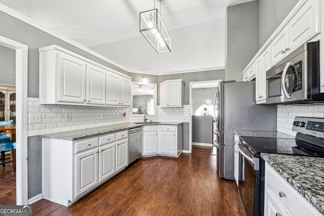 kitchen featuring sink, dark wood-type flooring, appliances with stainless steel finishes, white cabinets, and decorative light fixtures