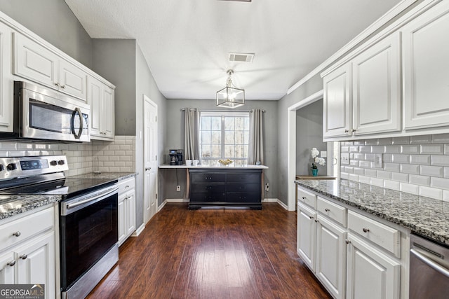 kitchen with white cabinetry, pendant lighting, light stone countertops, and appliances with stainless steel finishes