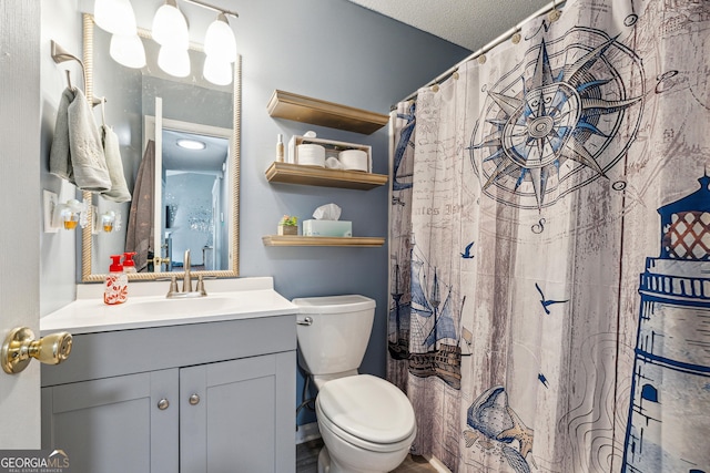 bathroom featuring vanity, a textured ceiling, and toilet