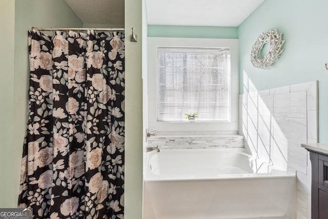 bathroom with vanity, a tub, and a textured ceiling