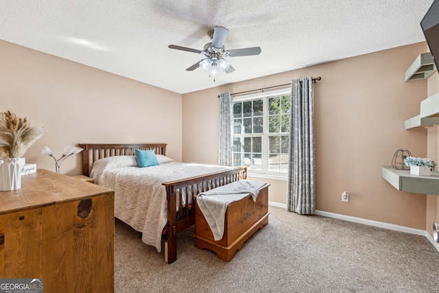 bedroom featuring ceiling fan, light colored carpet, and a textured ceiling