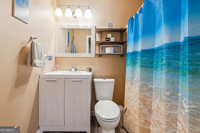 bathroom featuring vanity, toilet, and curtained shower