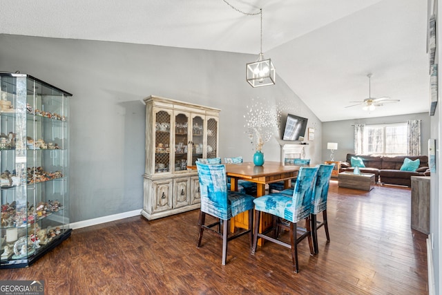 dining area with ceiling fan, dark hardwood / wood-style floors, and vaulted ceiling