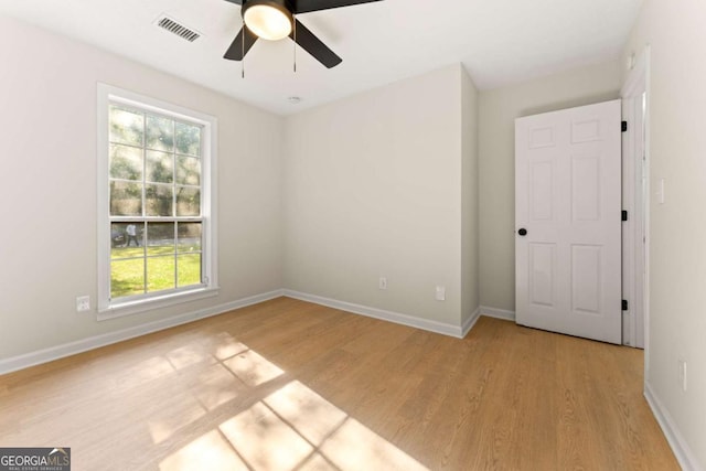 spare room with ceiling fan and light wood-type flooring