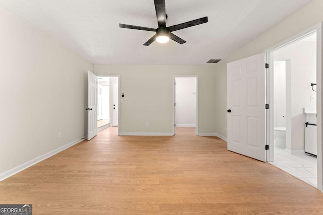 empty room with a textured ceiling, ceiling fan, and light hardwood / wood-style flooring