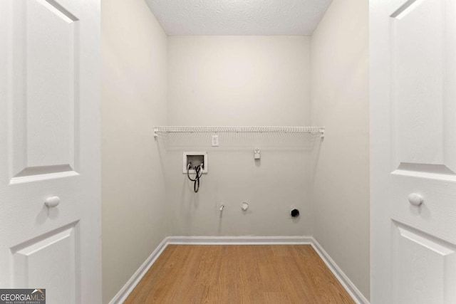 washroom with gas dryer hookup, hardwood / wood-style flooring, washer hookup, a textured ceiling, and hookup for an electric dryer