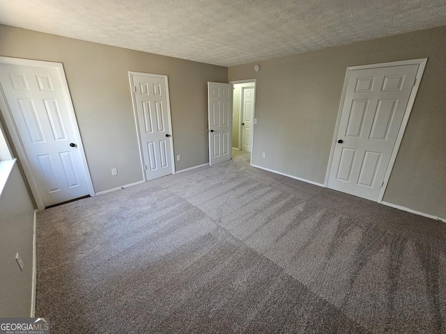 unfurnished bedroom with carpet floors and a textured ceiling