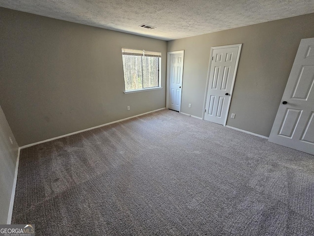 unfurnished bedroom featuring carpet and a textured ceiling