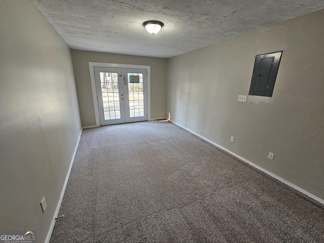 empty room with french doors, carpet flooring, electric panel, and a textured ceiling