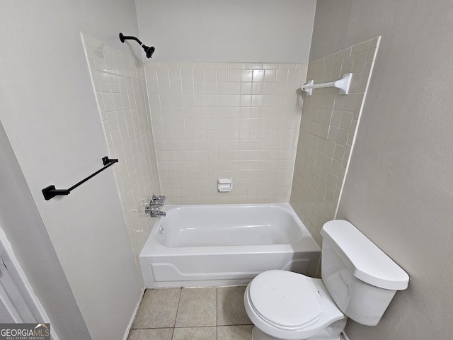 bathroom with tiled shower / bath, tile patterned floors, and toilet