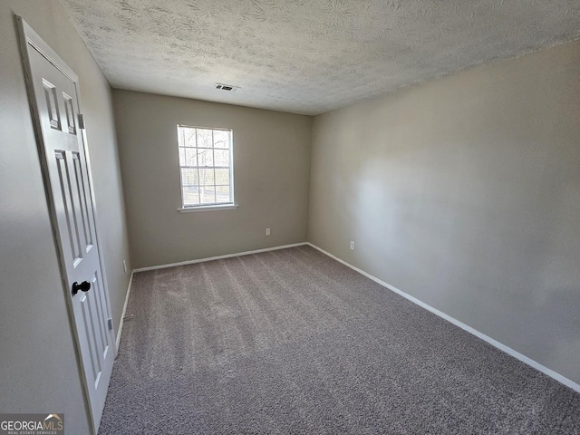 unfurnished room with carpet floors and a textured ceiling