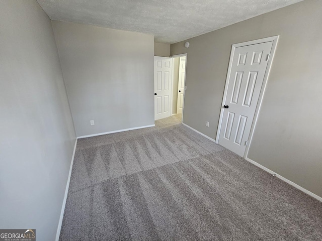 carpeted empty room featuring a textured ceiling