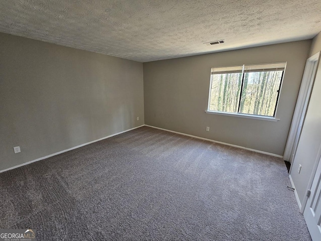 spare room featuring carpet floors and a textured ceiling