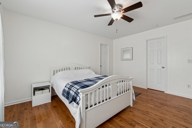 bedroom with ceiling fan and dark hardwood / wood-style flooring