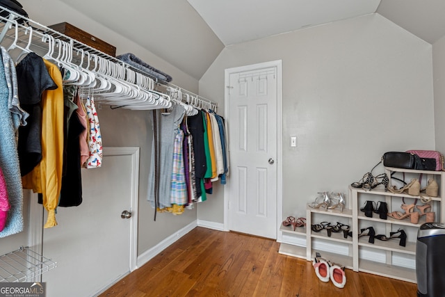 walk in closet featuring hardwood / wood-style flooring and vaulted ceiling