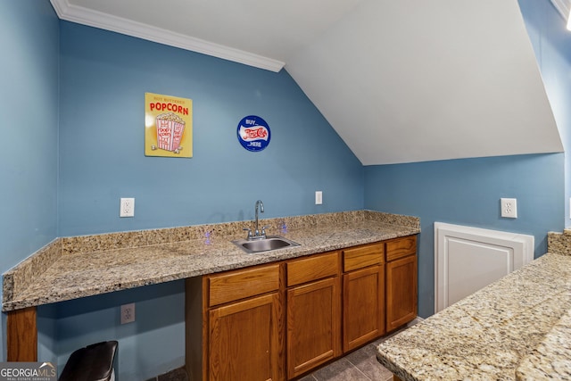 kitchen featuring tile patterned flooring, sink, crown molding, and vaulted ceiling