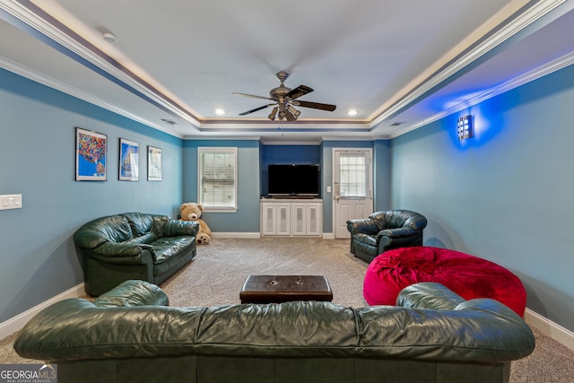 living room with crown molding, ceiling fan, carpet flooring, and a raised ceiling