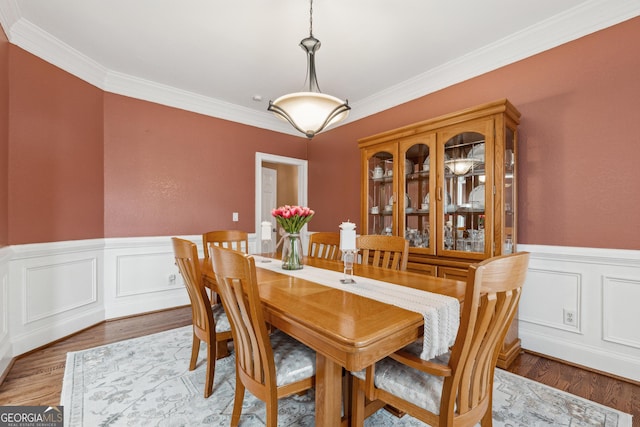 dining room with crown molding and hardwood / wood-style floors