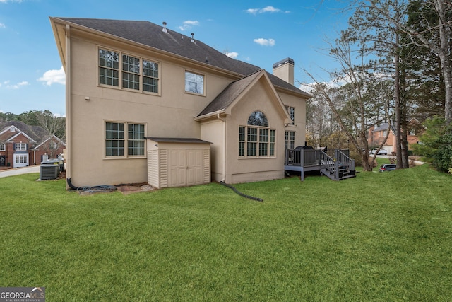 rear view of property featuring a wooden deck, a yard, and central AC unit