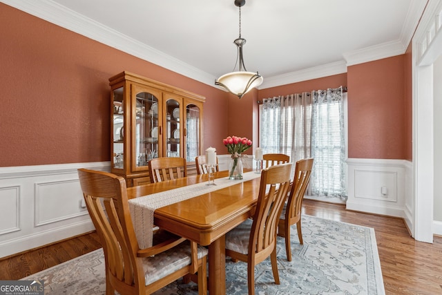 dining room featuring ornamental molding and light hardwood / wood-style flooring