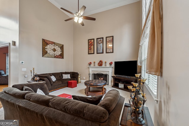 living room featuring lofted ceiling, ornamental molding, and ceiling fan