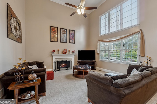 living room with ornamental molding, carpet floors, and ceiling fan