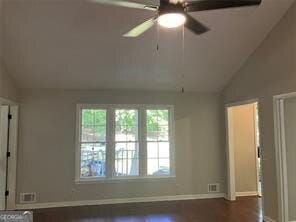 unfurnished room featuring vaulted ceiling, dark wood-type flooring, and ceiling fan