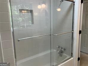 bathroom with shower / bath combination with glass door