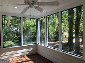 unfurnished sunroom featuring ceiling fan