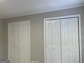 unfurnished bedroom with crown molding