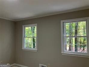 unfurnished room with crown molding