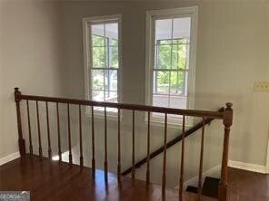 stairway with hardwood / wood-style floors and a healthy amount of sunlight