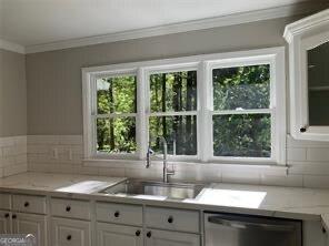 kitchen featuring ornamental molding, dishwasher, sink, and white cabinets