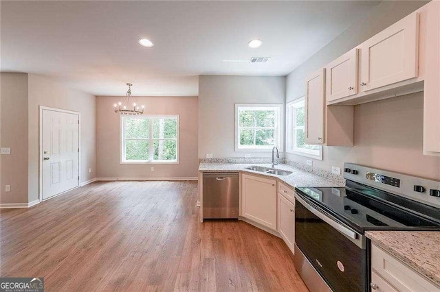 kitchen featuring sink, white cabinetry, decorative light fixtures, plenty of natural light, and stainless steel appliances