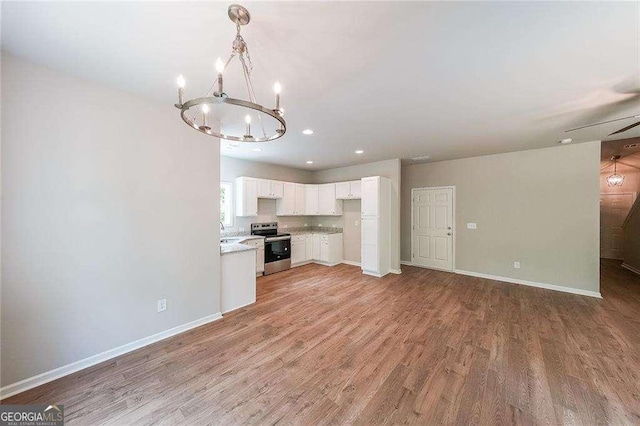 kitchen with sink, stainless steel range with electric cooktop, white cabinetry, light hardwood / wood-style flooring, and pendant lighting