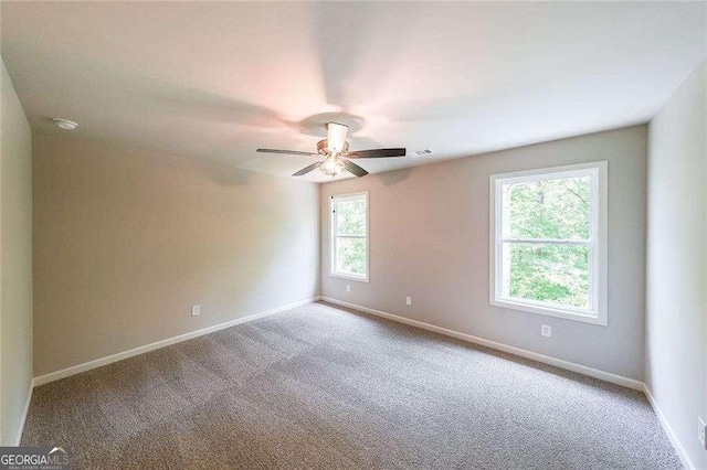 carpeted spare room featuring ceiling fan