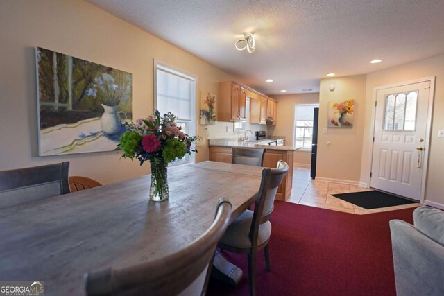 tiled dining area with sink and a textured ceiling