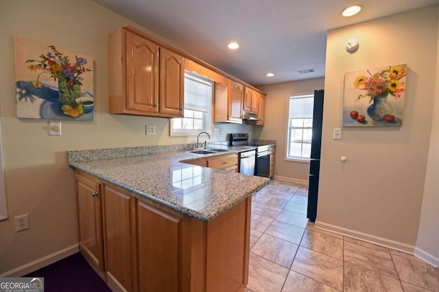 kitchen with appliances with stainless steel finishes, sink, light tile patterned floors, kitchen peninsula, and light stone countertops