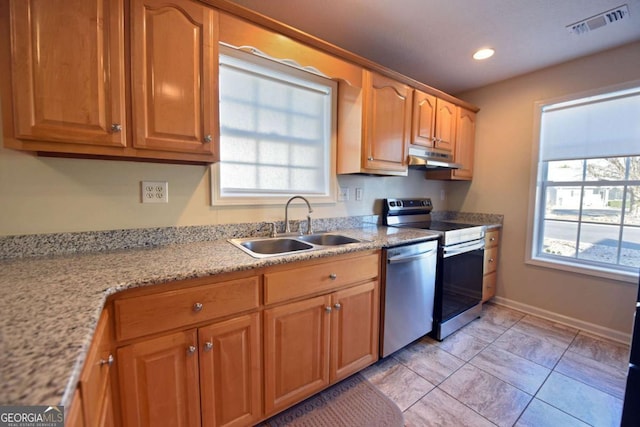 kitchen with appliances with stainless steel finishes, sink, light tile patterned floors, and light stone counters