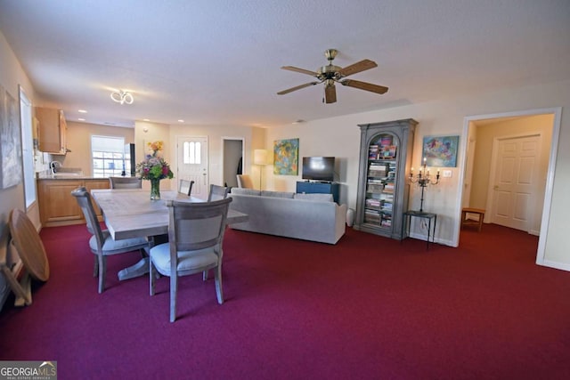 dining room with ceiling fan and dark carpet