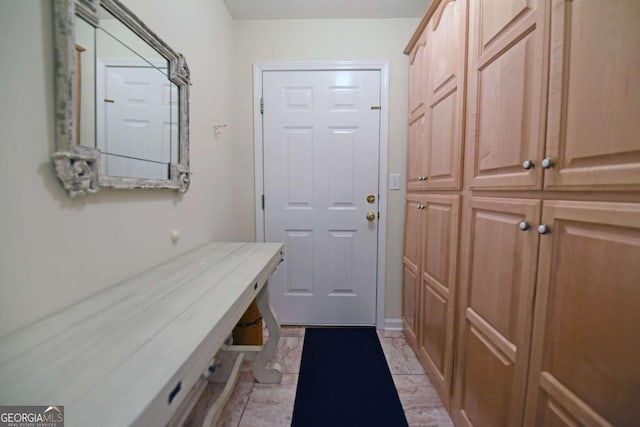 mudroom with light tile patterned floors and a textured ceiling