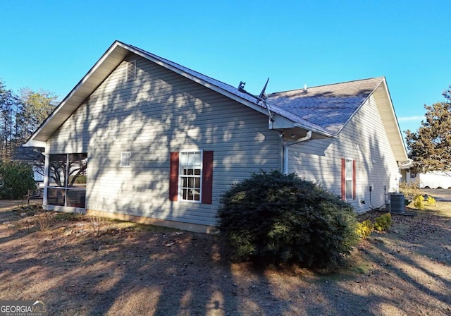 view of property exterior with a sunroom and central air condition unit