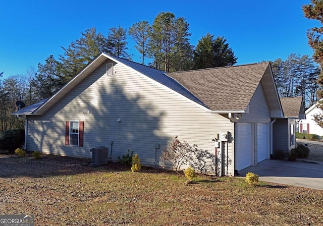 view of side of property featuring central AC unit and a garage