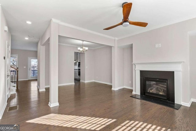 unfurnished living room featuring ceiling fan with notable chandelier, dark wood-type flooring, and ornamental molding