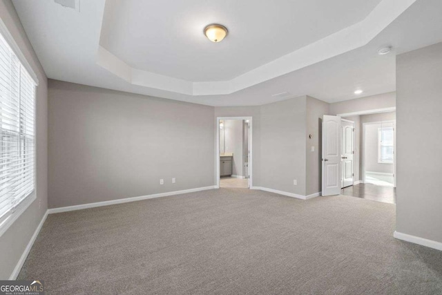 carpeted spare room with a tray ceiling