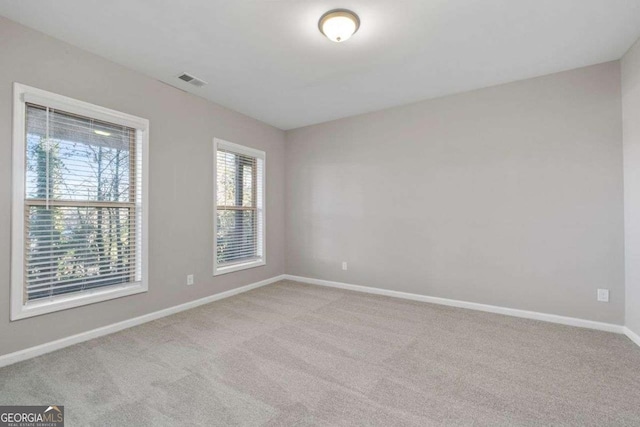 spare room featuring light colored carpet