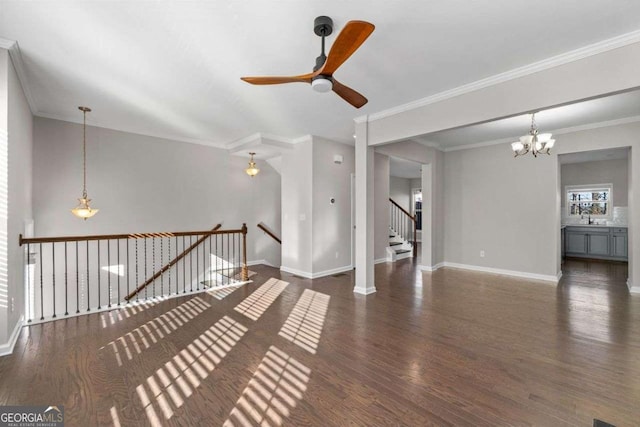 unfurnished living room with crown molding, dark wood-type flooring, and ceiling fan with notable chandelier