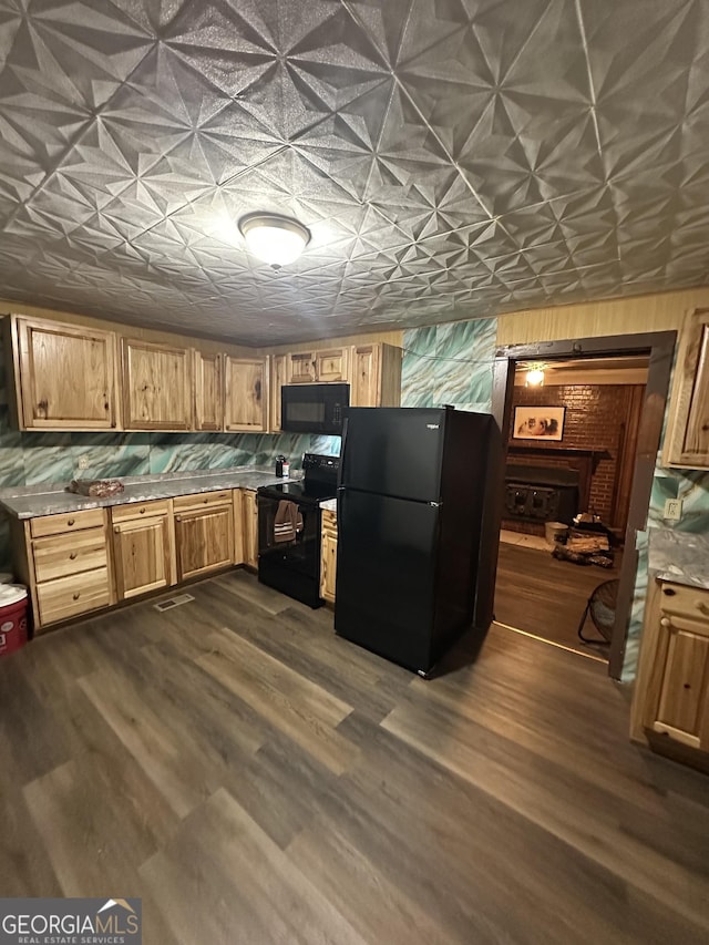 kitchen with dark hardwood / wood-style flooring and black appliances