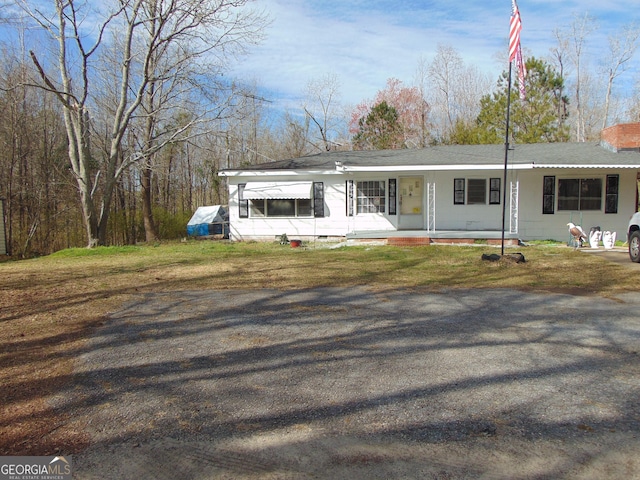 view of front of home featuring a chimney, a porch, and a front lawn